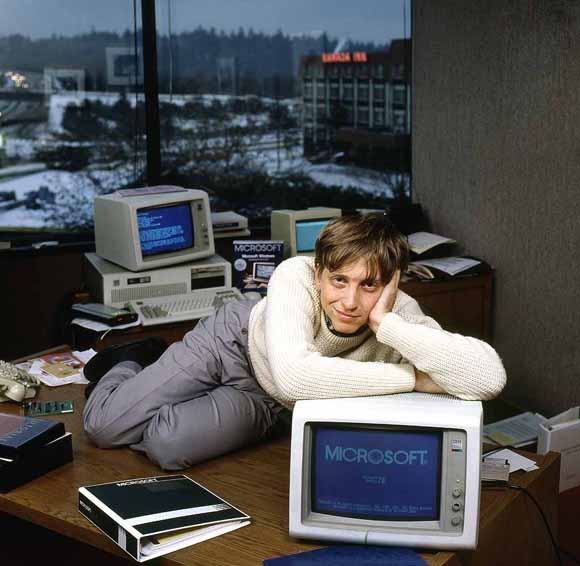 Bill Gates posing on table 80s