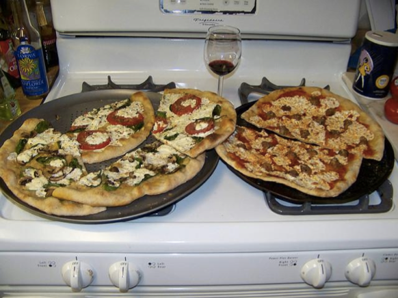 Two pizzas sitting on top of a stove oven